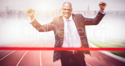 Composite image of successful businessman raising arms