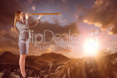 Composite image of businesswoman looking through a telescope