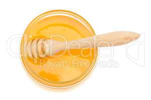 pot with honey and drizzler on a white background