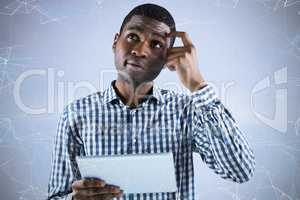 Composite image of young businessman thinking and holding tablet