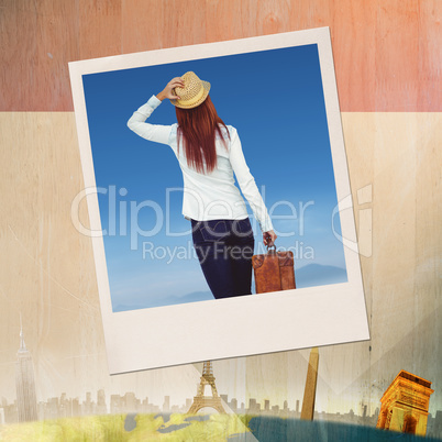 Composite image of rear view of hipster woman holding suitcase