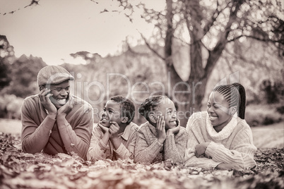 Portrait of a young smiling family lying in leaves