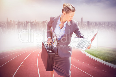 Composite image of businesswoman looking at her laptop