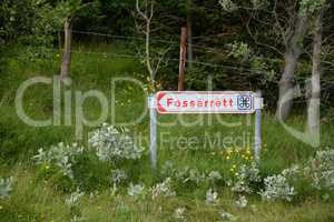 Schild an einem Wasserfall auf Island