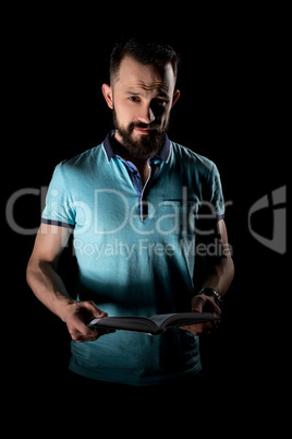 Studio photo of bearded man with book in his hands