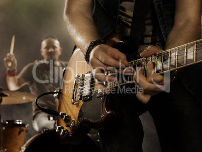 Rock band performs on stage. Guitarist.