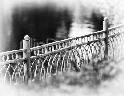 Horizontal diagonal black and white fence in park bokeh vignette
