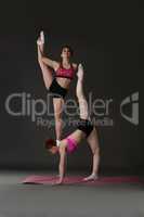 Studio photo of female acrobats training in pair