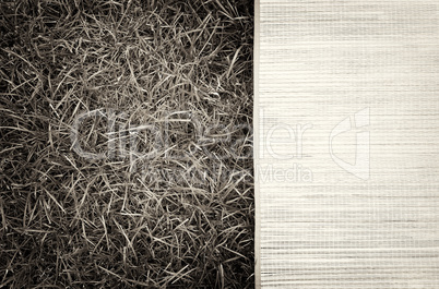 Horizontal vintage sepia picnic bamboo bedding on grass backgrou