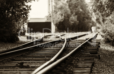 Horizontal black and white sepia railroad track bokeh with peopl