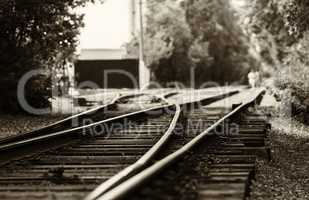 Horizontal black and white sepia railroad track bokeh with peopl