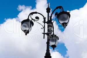 Vintage lamp on blue sky with clouds background