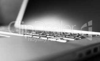 Horizontal black and white laptop keyboard bokeh background