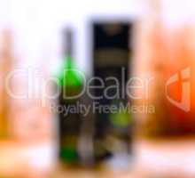 Vertical bottle of alcohol with glass and box bokeh background