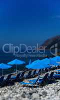 Vertical vivid beach blue umbrellas bokeh background backdrop