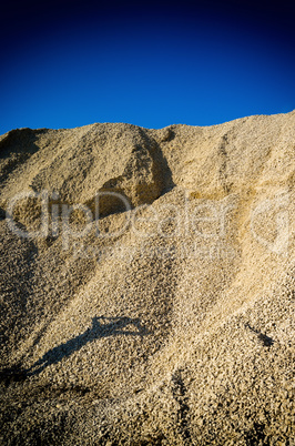 Vertical vibrant heap of rock with human shadow composition