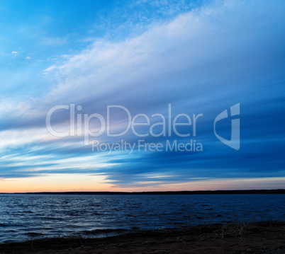 Square dramatic sunset on lake horizon long exposure background