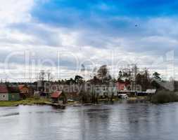 Horizontal dramatic houses on Karelian river bank  background ba