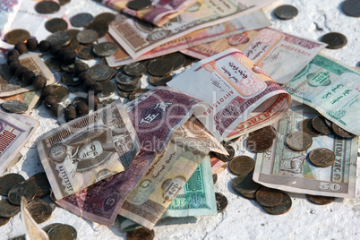 Pile of money notes and coins of different countries