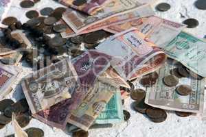 Pile of money notes and coins of different countries