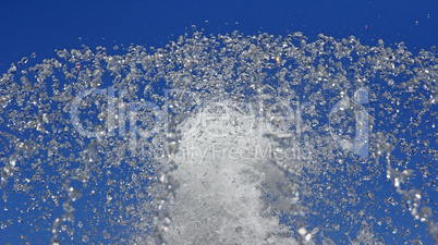 Fountain drops of pure water against a blue sky.