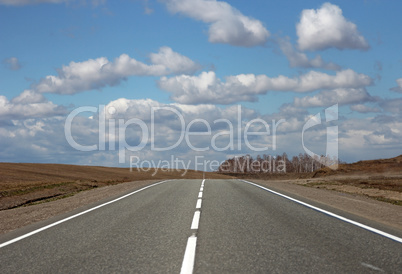 Asphalt road and clouds on blue sky in sunny day