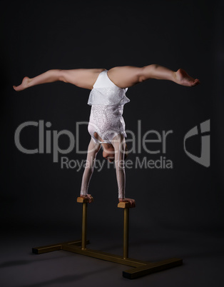 Charming gymnast doing handstand on circus stands