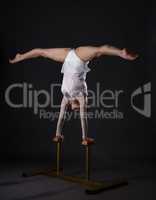 Charming gymnast doing handstand on circus stands