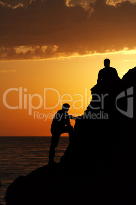 Two silhouette of people in beautiful sunset