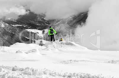 Freeriders on off-piste slope and mountains in mist. Selective c