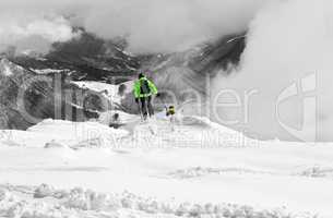 Freeriders on off-piste slope and mountains in mist. Selective c