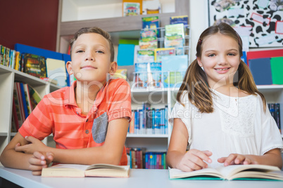 Schoolkids reading book in library