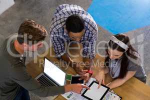 High angle view of colleagues using technologies