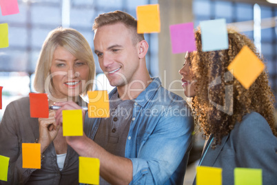 Businessman explaining to colleagues over sticky notes