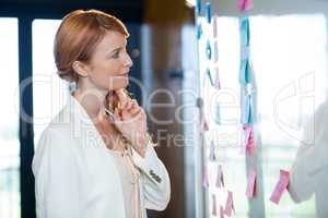Pretty businesswoman looking at sticky notes