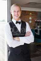 Waiter with arms crossed in restaurant