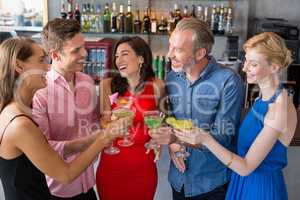 Group of friends toasting glasses of cocktail