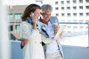 Happy woman with man using digital tablet