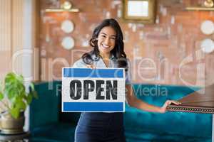 Smiling waitress holding a board with open sign in restaurant