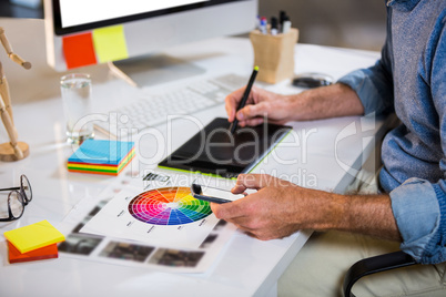 Midsection of businessman using graphics tablet