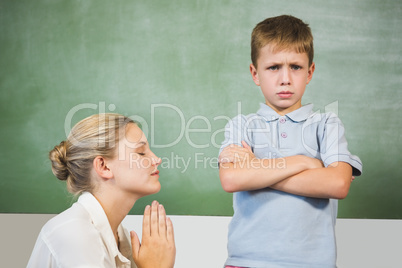 Female teacher apologizing boy in the classroom