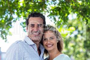 Smiling couple against tree