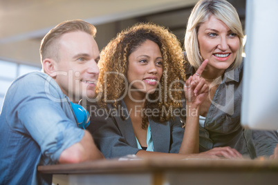 Creative young business people looking at computer