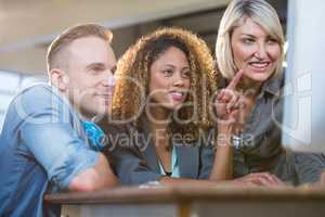 Creative young business people looking at computer