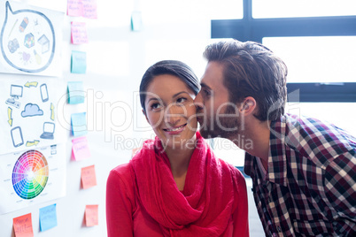 Man kissing female colleague in office