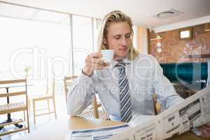 Man having coffee while reading newspaper