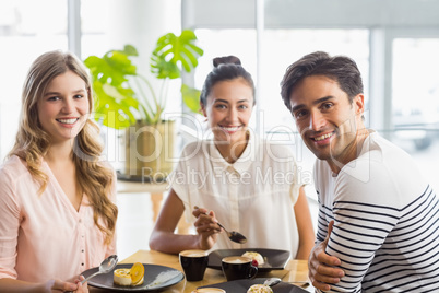 Group of happy friends having dessert together