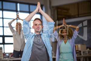 Business people smiling while practicing yoga