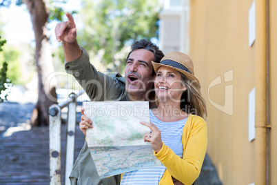 Couple with map standing on walkway