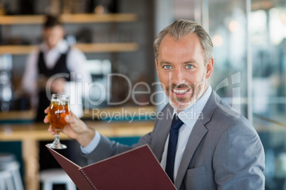 Businessman holding glass of beer and menu